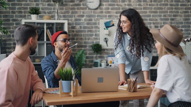 A diverse group of young professionals discussing a project in a stylish office setting.