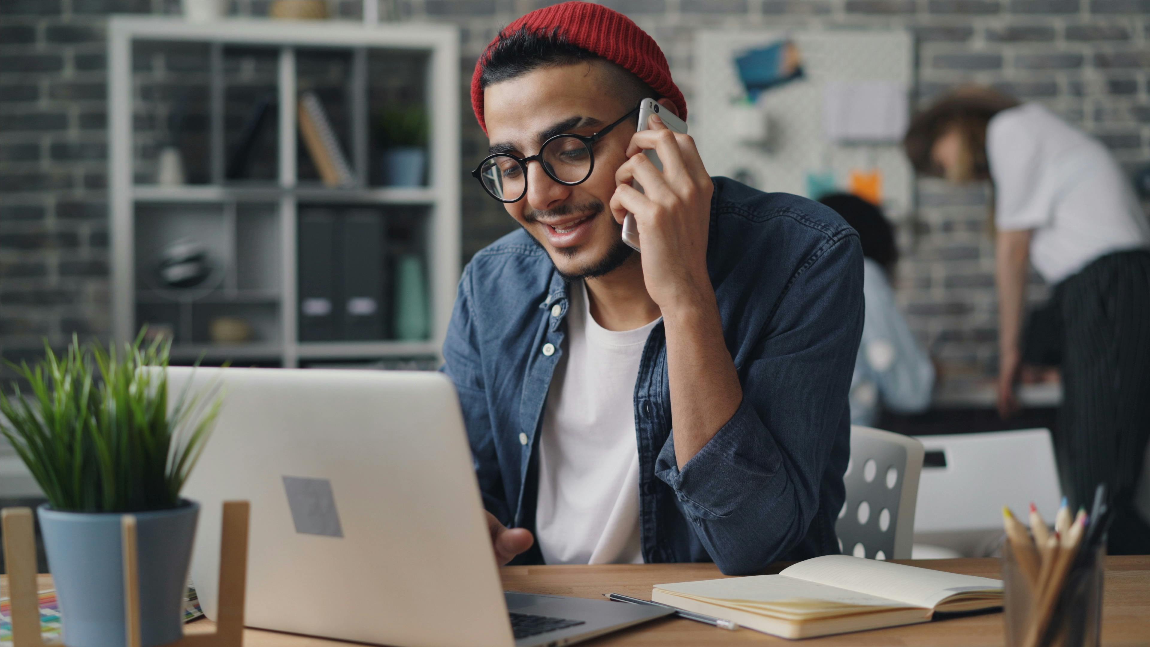 a man in glasses talking on a cell phone