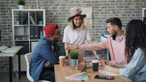 Colleagues brainstorming around a table in a studio — photo by Vitaly Gariev on Pexels