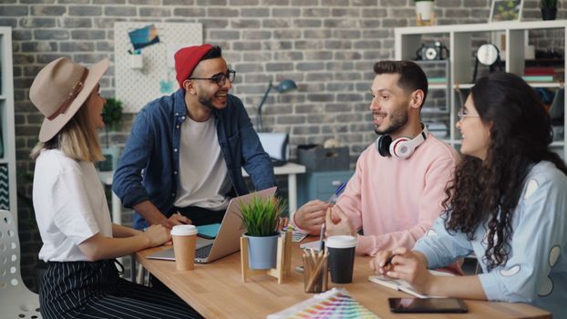 A diverse group of young adults having a brainstorming session in a stylish office setting.