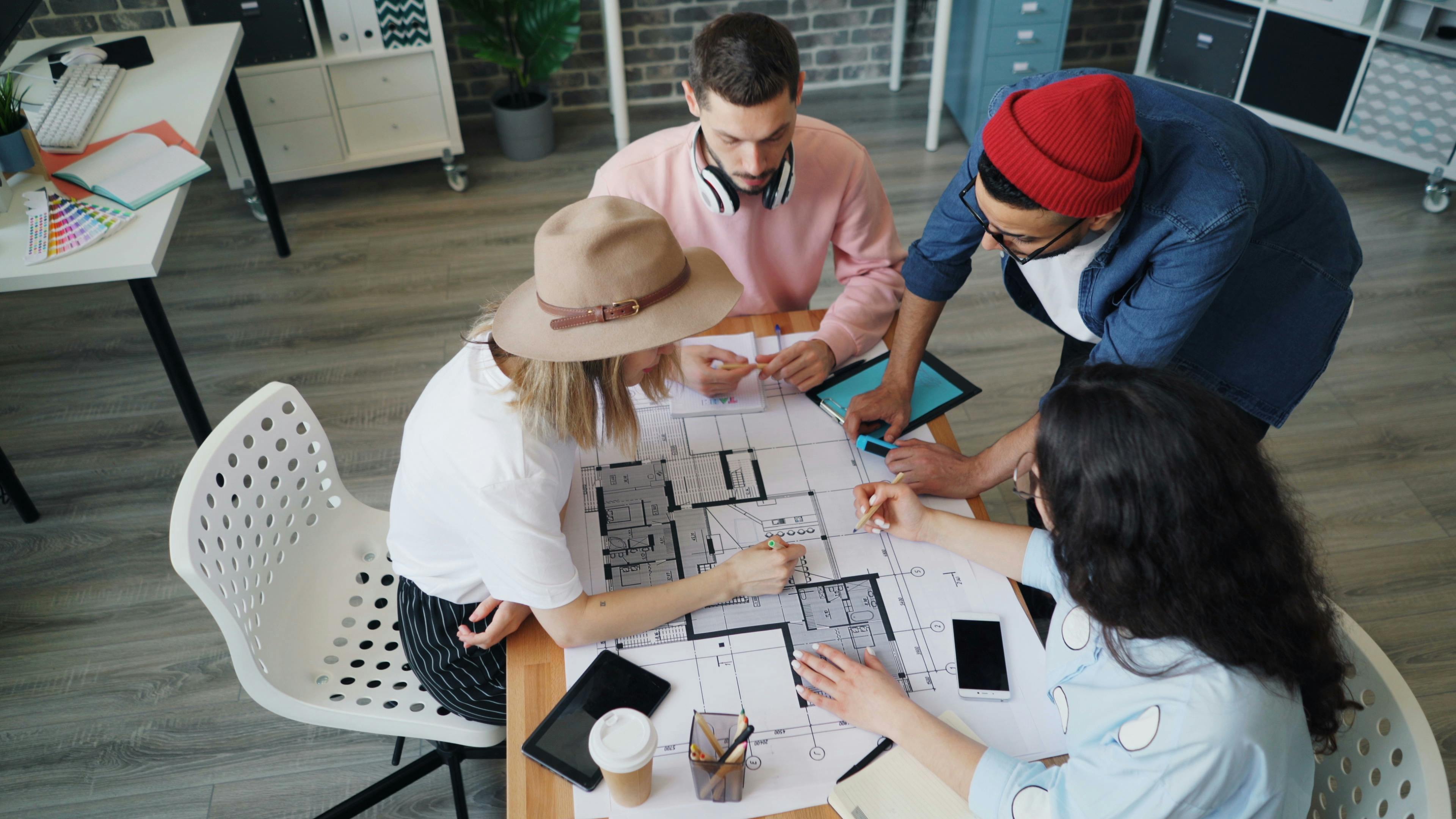 interior designers talking over house construction drawing