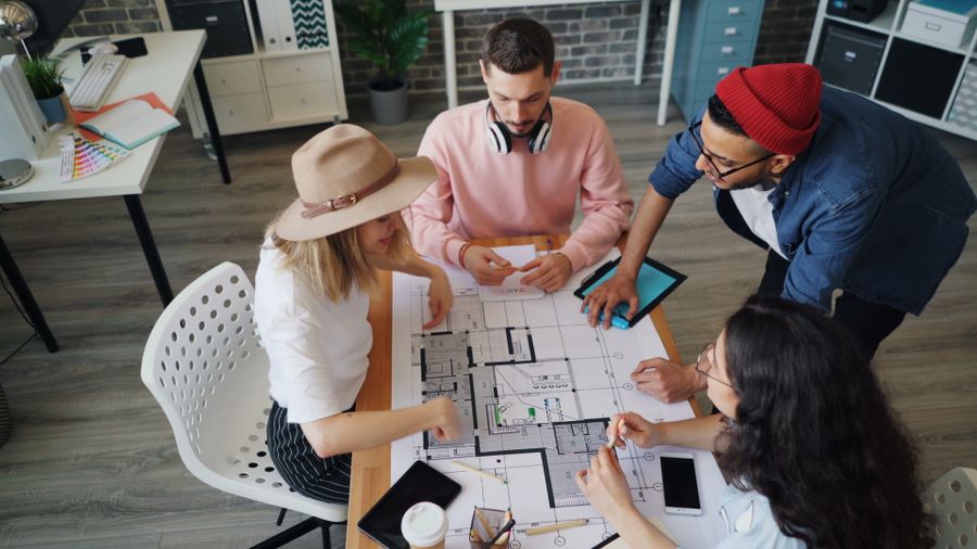 The studio reviewing layout boards around the big table — photo by Vitaly Gariev on Pexels