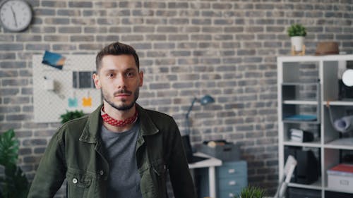 A man standing in front of a brick wall