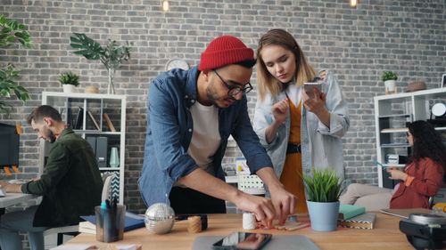 Free Team of diverse young adults collaborating creatively in a modern office space. Stock Photo