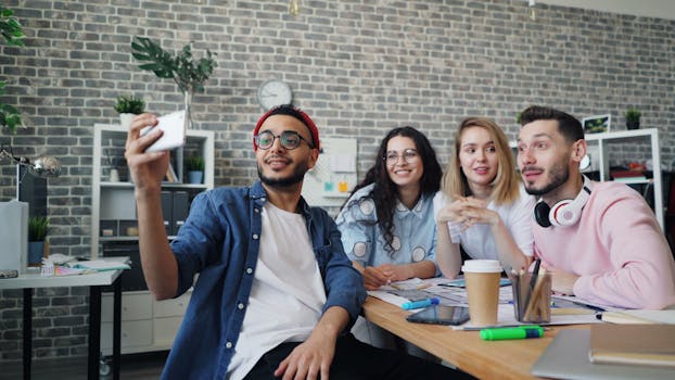 A lively group of young professionals taking a selfie in an urban office setting, showcasing teamwork and modern lifestyle.