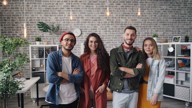 A cheerful group of young professionals smiling confidently in a modern office setting.
