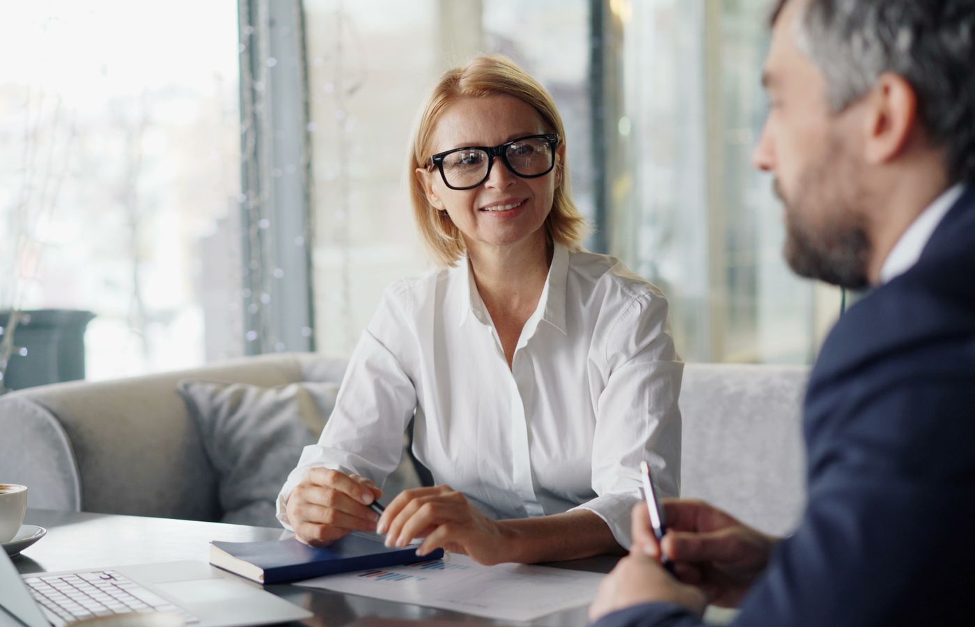 Confident businesspeople discussing strategies in a modern office setting.