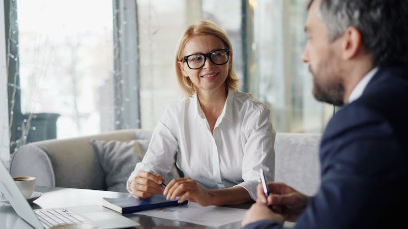 Two professionals having a supportive conversation in an office