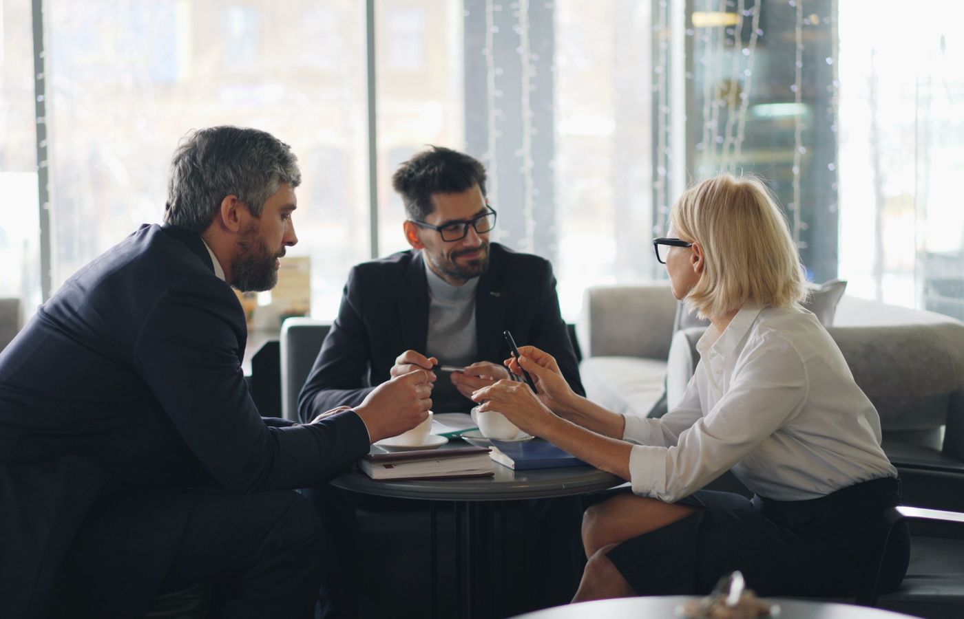 Professionals in a café discussing strategies and ideas in a group meeting.