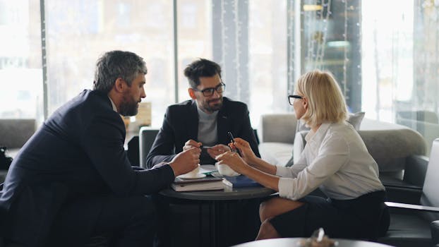 Professionals in a café discussing strategies and ideas in a group meeting.