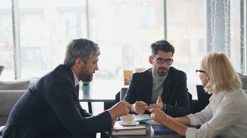 Three business people sitting at a table talking