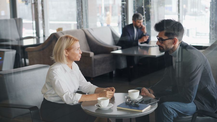 Two coworkers meeting over coffee in a cafe — photo by Vitaly Gariev on Pexels