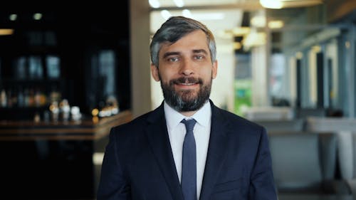 A man in a suit and tie standing in front of a bar