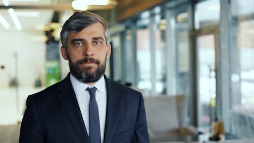 A man in a suit and tie standing in an office