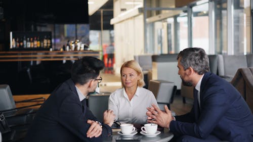 Three business people sitting at a table talking