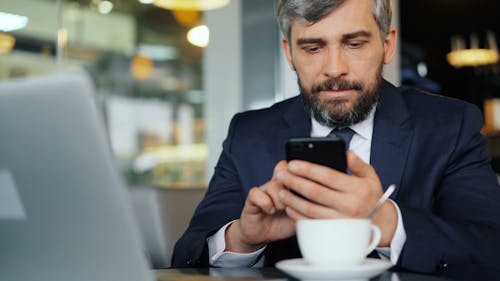 A man in a suit looking at his phone