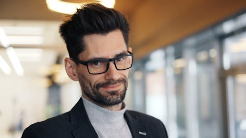 A man with glasses and a beard in a business suit