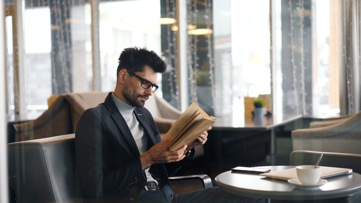 A man in a suit is reading a book