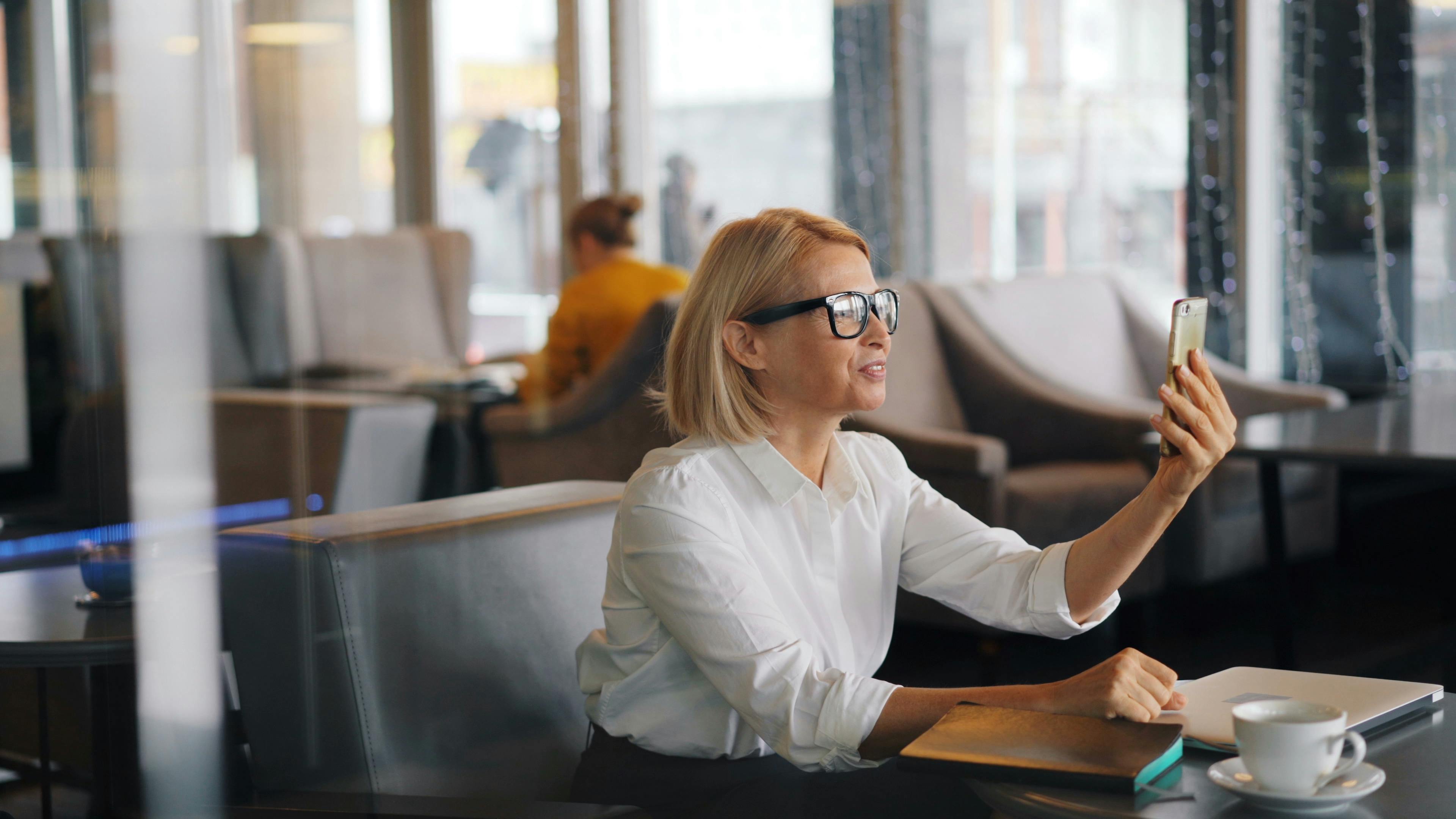 a woman sitting at a table with her phone