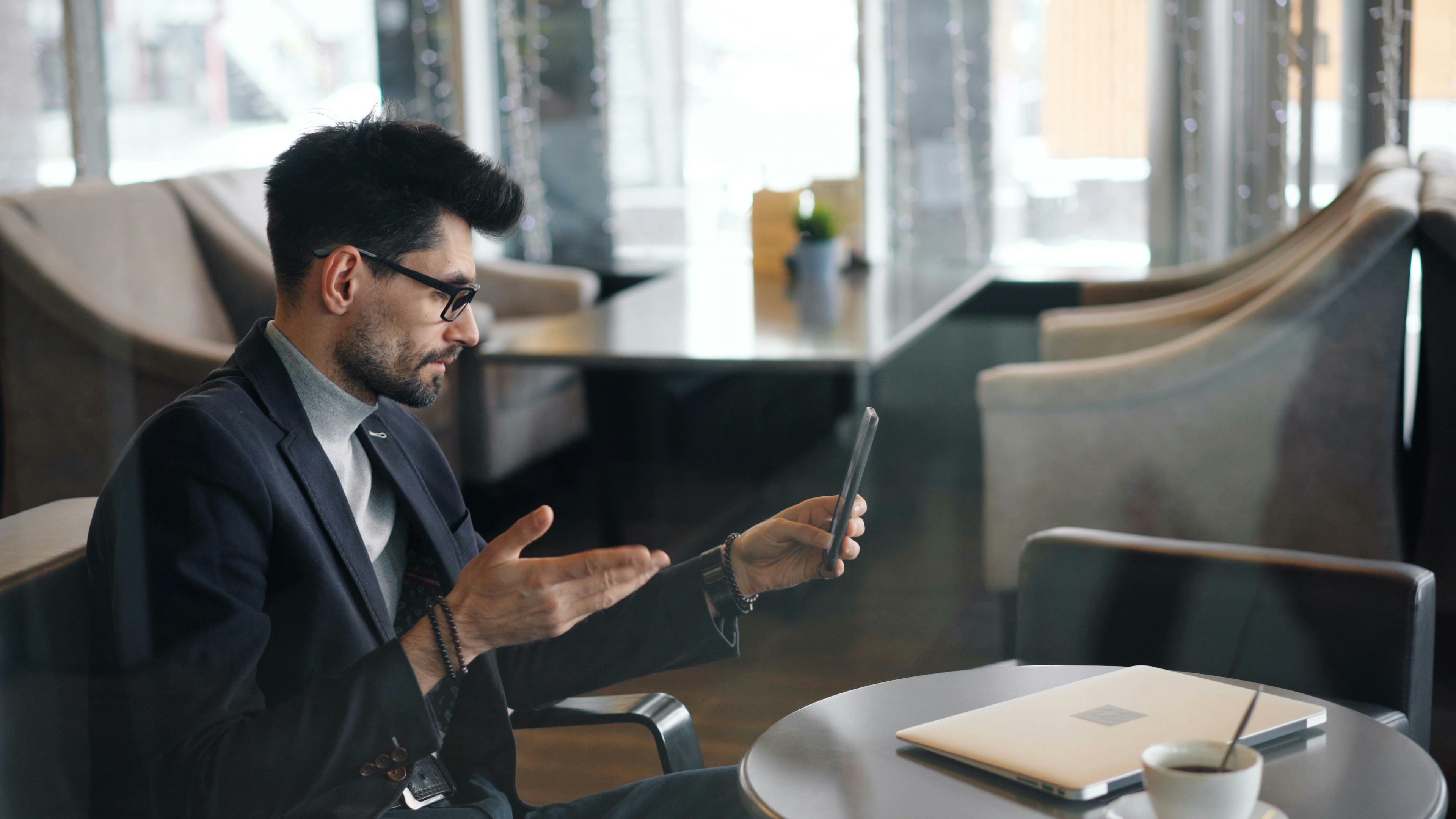 a man in a suit sitting at a table with a laptop