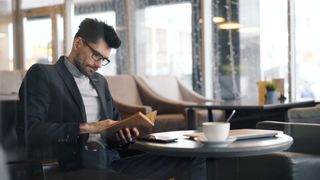 Reader in a window-lit café — Vitaly Gariev on Pexels