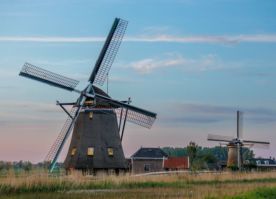 Beautiful windmills in Maasland, Netherlands at sunset, capturing scenic rural charm.