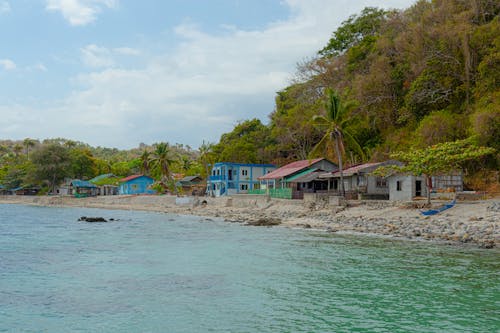 A beach with a blue water and a few houses