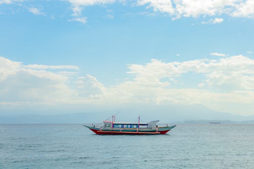 A boat is floating in the ocean with a blue sky