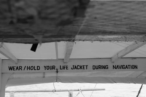 A sign that says wear hold your life jacket during navigation