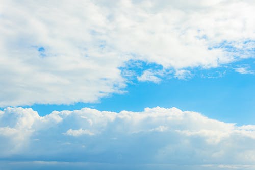 A blue sky with white clouds and a blue ocean