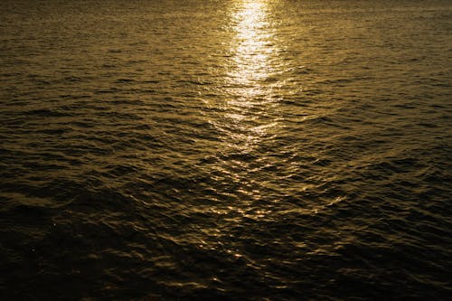 A sunset over the ocean with a boat in the water