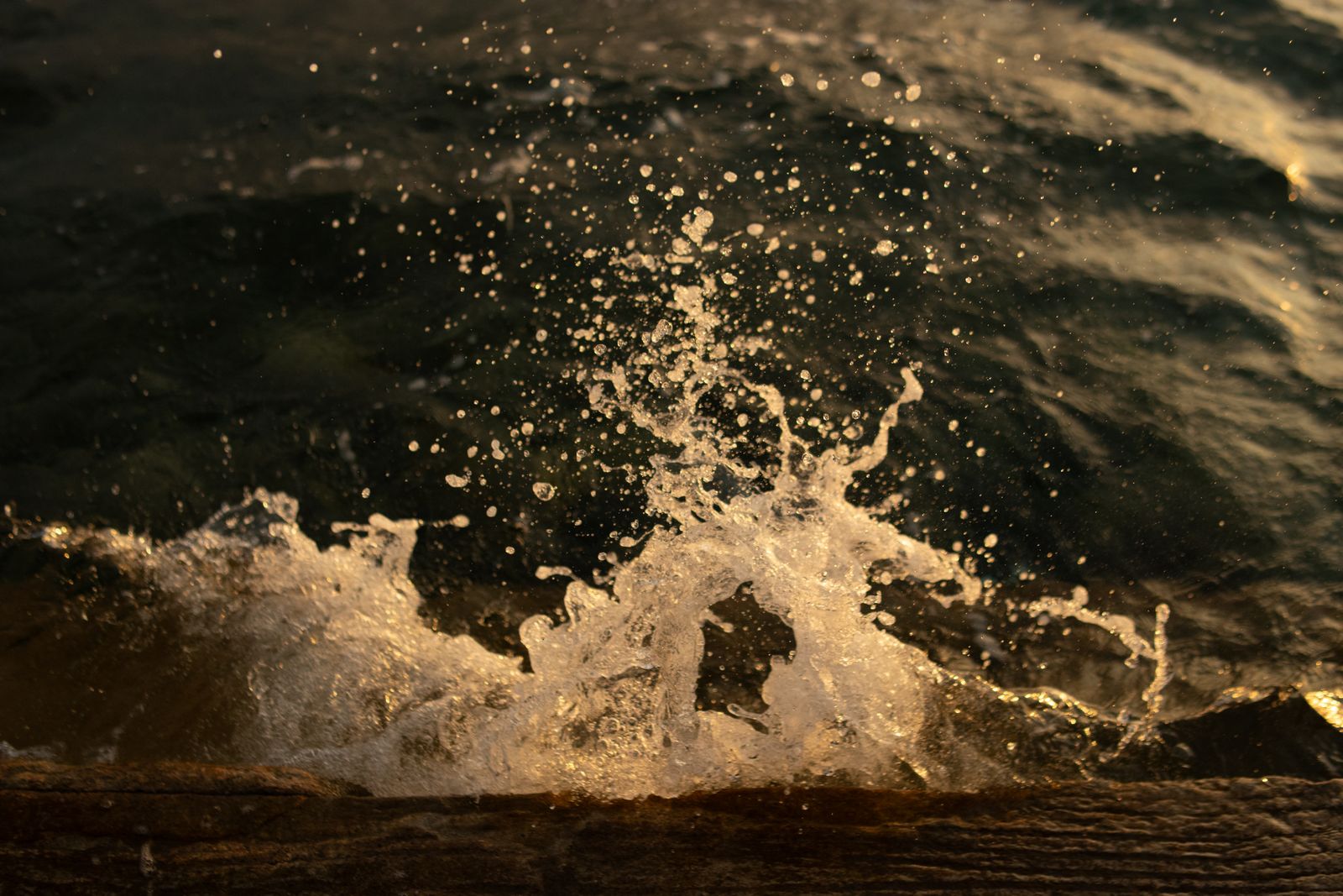 Ocean spray backlit at golden hour, photo by Nothing Ahead on Pexels