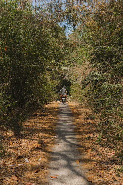 A person riding a motorcycle down a dirt road