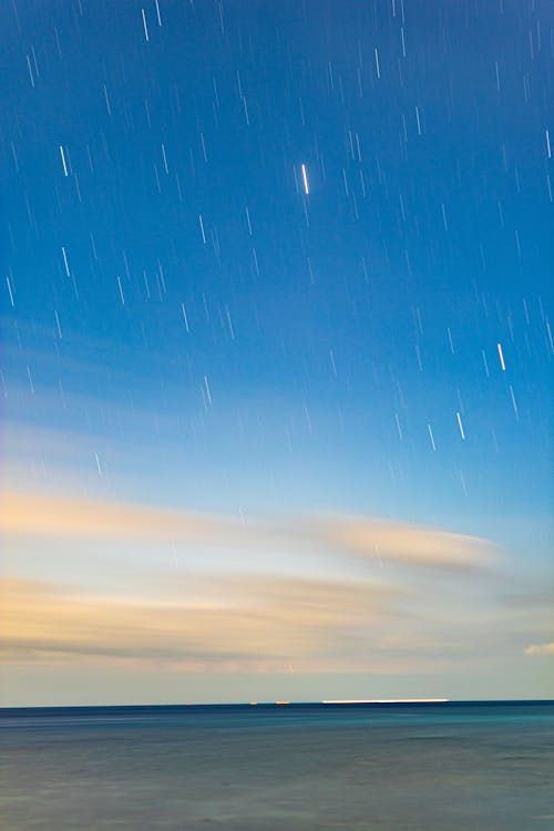 A long exposure photograph of stars over the ocean