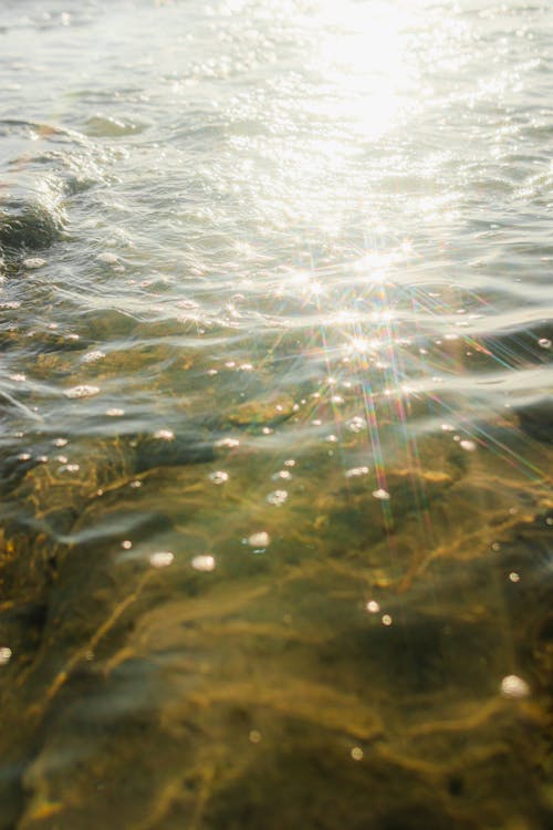 A close up of the water with sun shining through