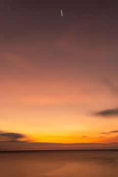 Calming sunset over the ocean with blurred horizon and colorful sky tones.