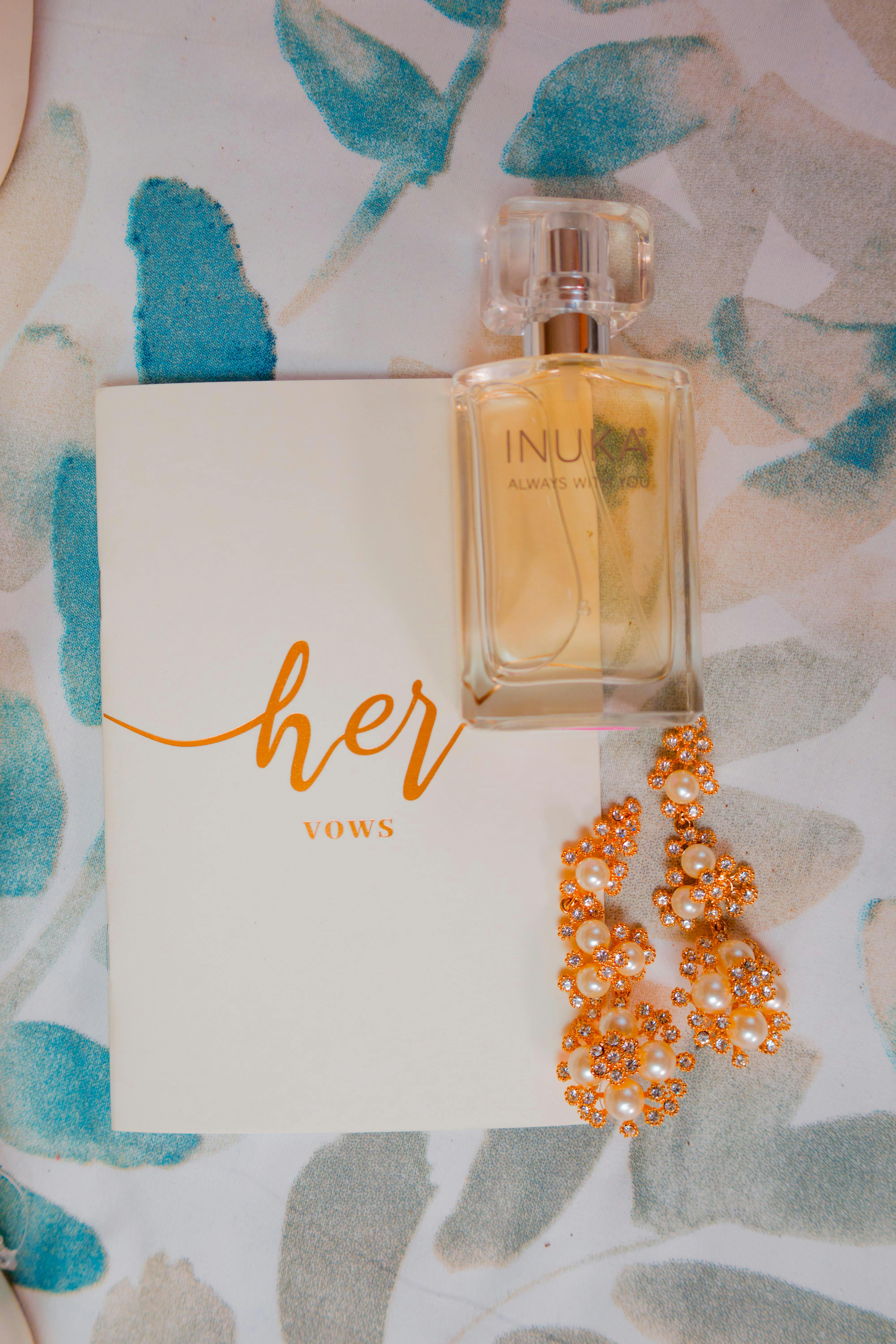 a bottle of perfume earrings and a card with wedding vows