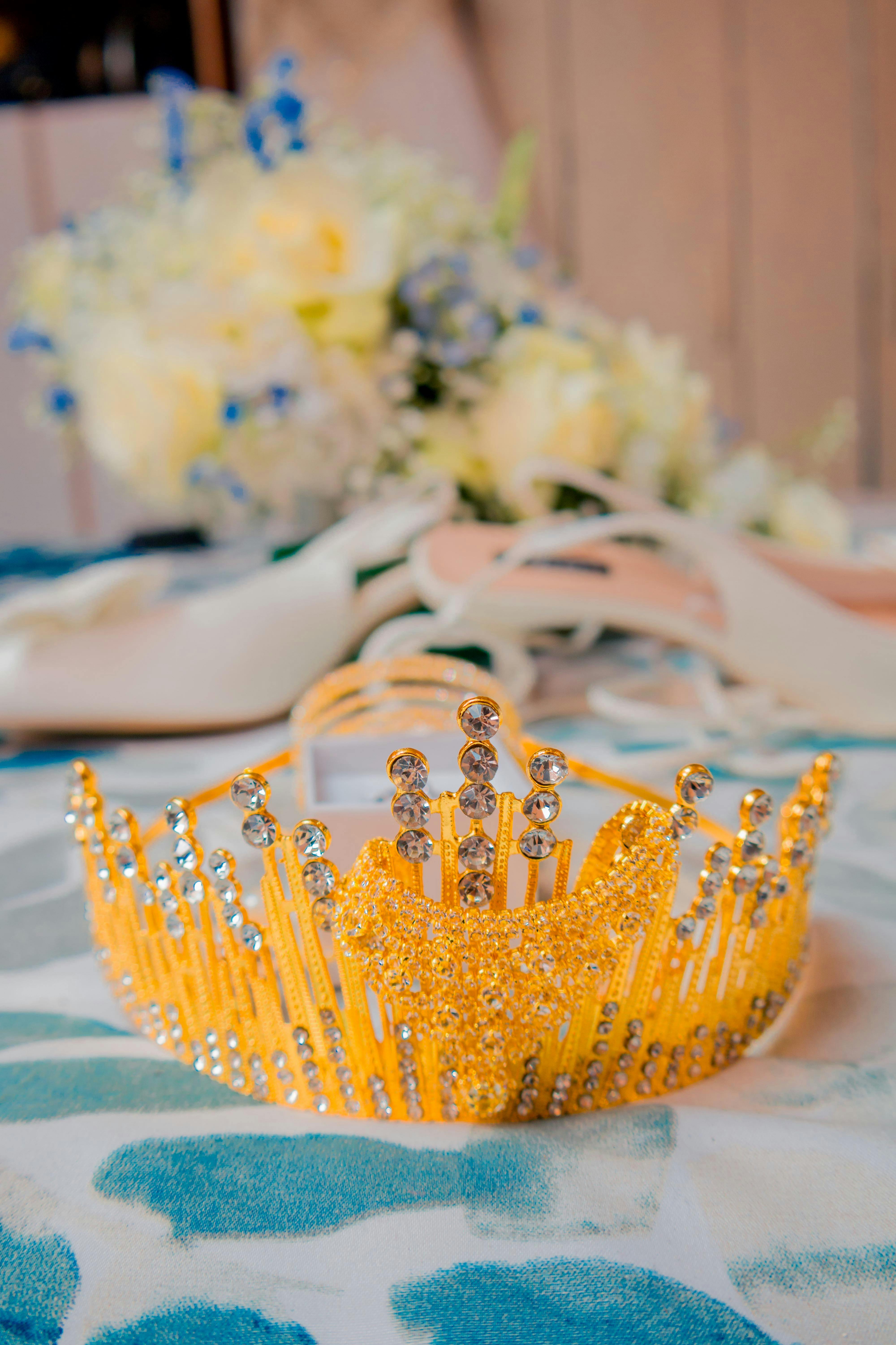 close up of a golden tiara lying in front of heels and a bouquet