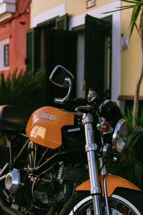 Free Classic orange Ducati motorcycle parked in front of colorful buildings in Palma, Spain. Stock Photo