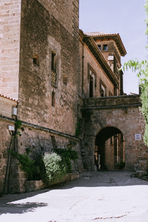 A stone building with a clock tower and a stone archway