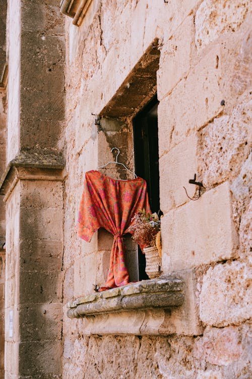 A window with a red and white scarf hanging from it