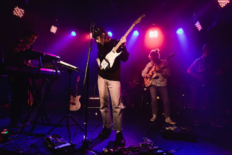 Group Of People Performing On Stage Using Musical Instruments