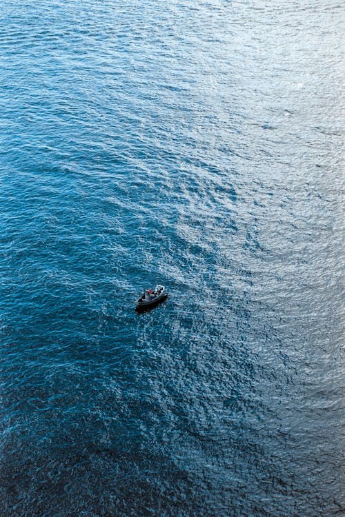 A boat floating in the ocean with a person on it