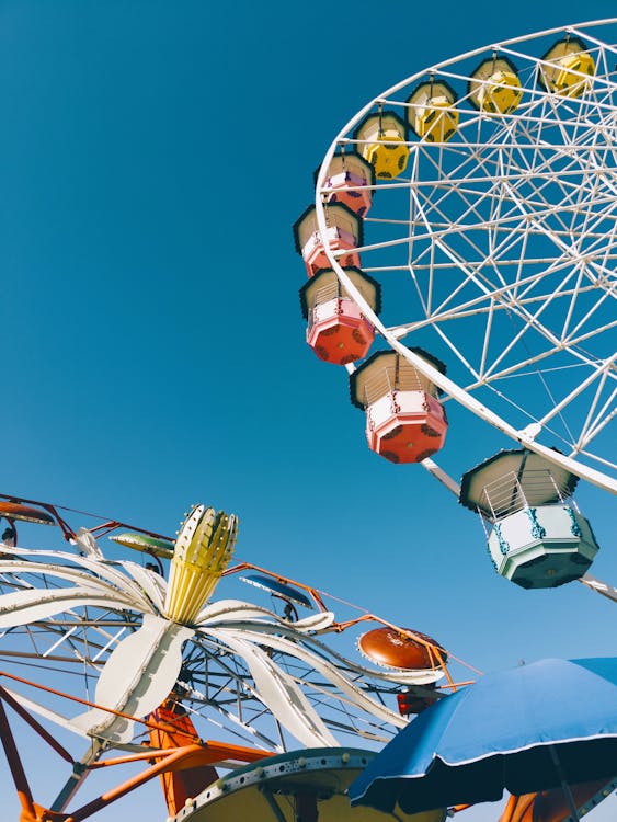 A ferris wheel and other rides against a blue sky