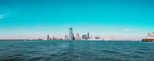 Free Buildings Beside Body of Water Under Blue Sky Stock Photo