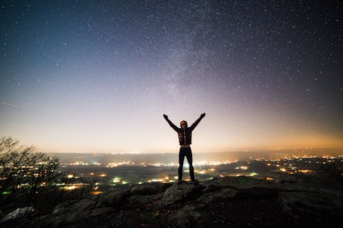 Person Standing And Raising Both Hands