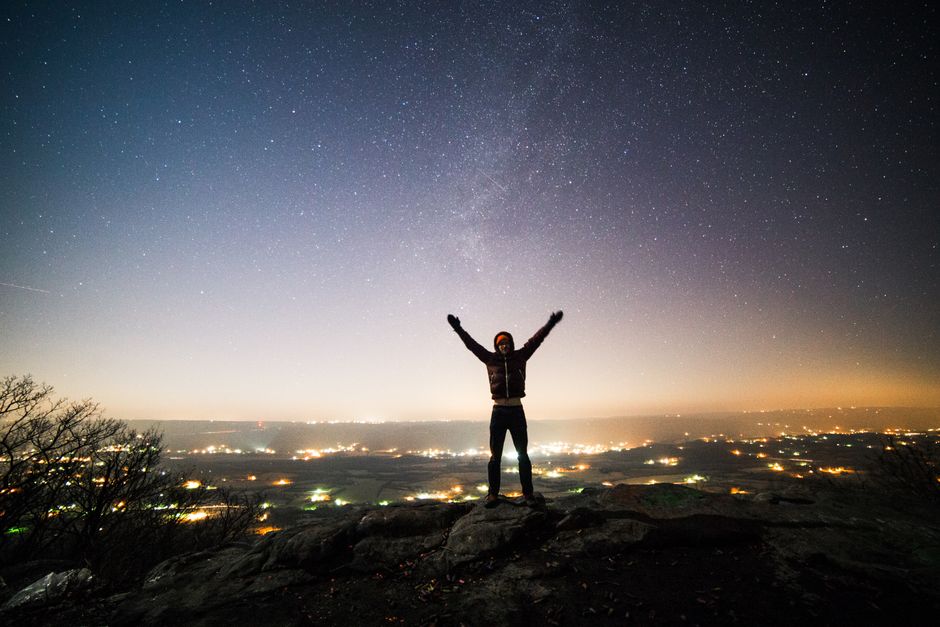 Silhouette of a person gazing at a starry night sky over Dunlap, TN.