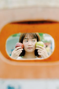 透过彩色相框，可以看到一位拿着苹果的年轻女子的肖像