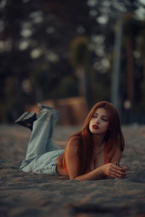Free A stylish woman with long hair lying on a beach in summer, showcasing fashion and leisure. Stock Photo
