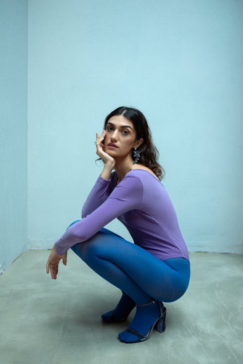 A woman in blue tights squatting down